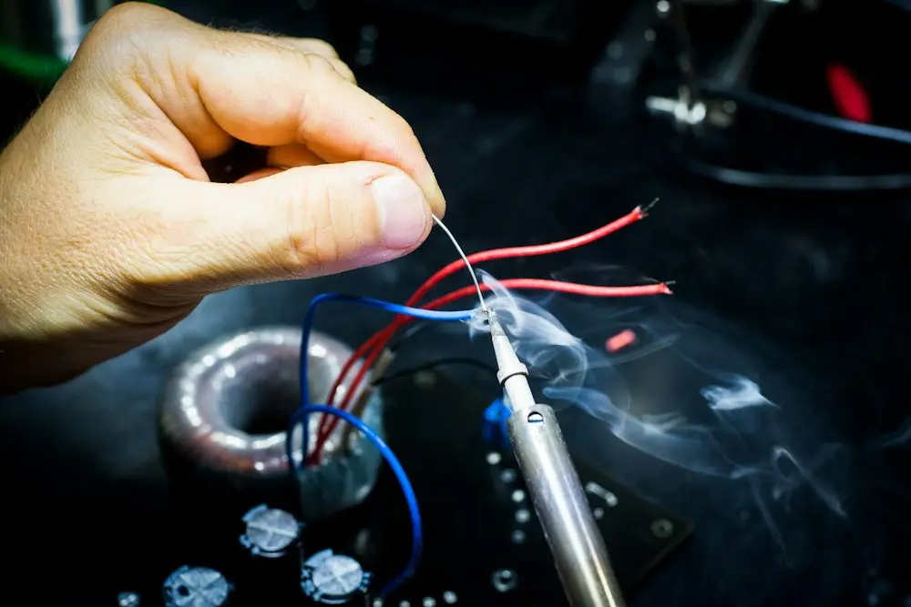 Tecnico che effettua una riparazione su un circuito elettronico